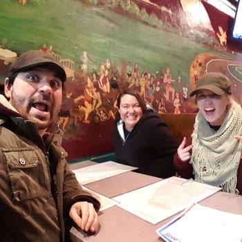 Three smiling people having dinner